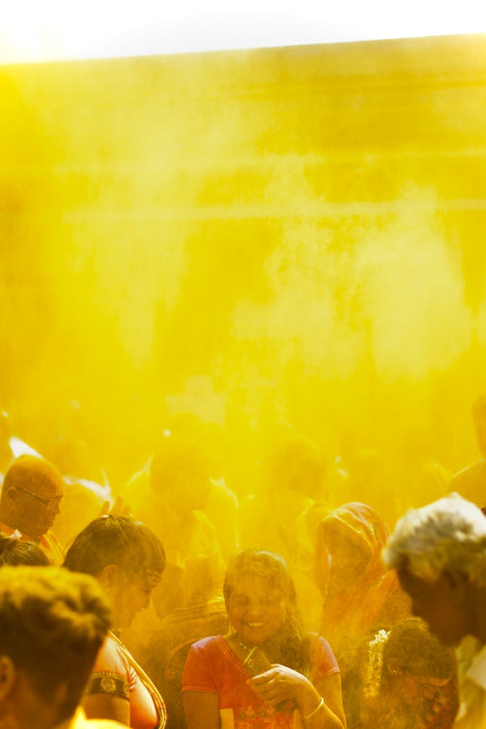 People enjoy Holi festival with vibrant yellow powder, celebrating joy and culture.